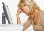 Frustrated Woman at Computer With Stack of Paper --- Image by © Royalty-Free/Corbis